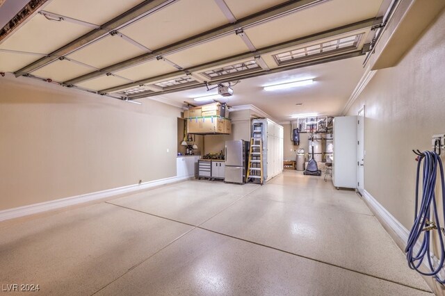 garage featuring stainless steel fridge and a garage door opener