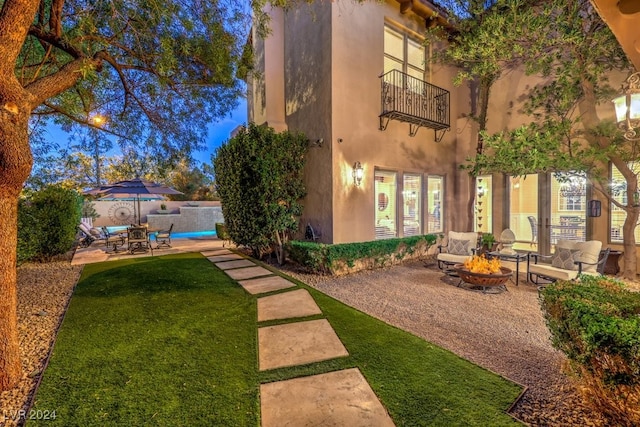 view of yard with a patio, a balcony, and a swimming pool