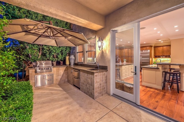 view of patio featuring a grill, sink, and an outdoor kitchen