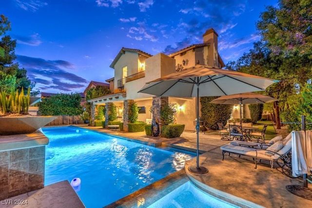 pool at dusk with a patio