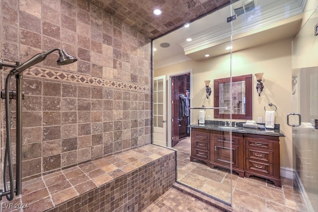 bathroom with vanity, a shower with door, tile walls, and crown molding