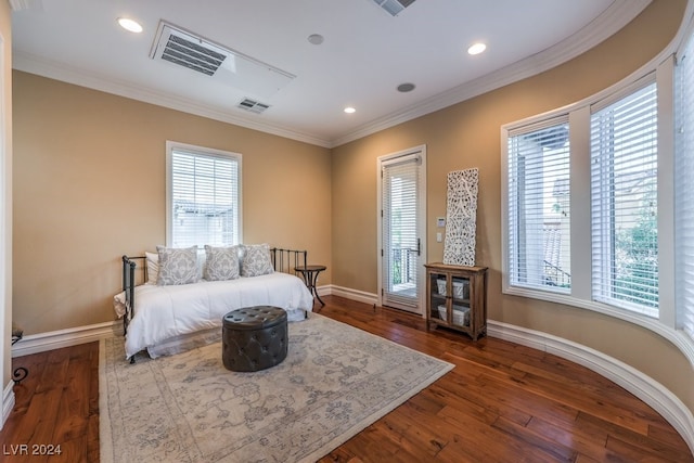 bedroom featuring dark hardwood / wood-style flooring, ornamental molding, and multiple windows