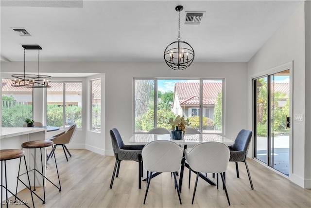 dining space featuring light hardwood / wood-style floors and a notable chandelier