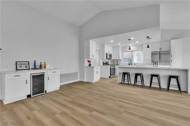 kitchen with wine cooler, white cabinetry, and stainless steel appliances