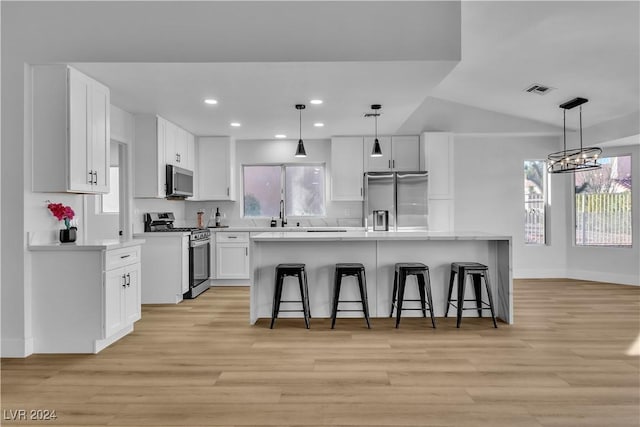 kitchen with appliances with stainless steel finishes, a center island, and white cabinetry