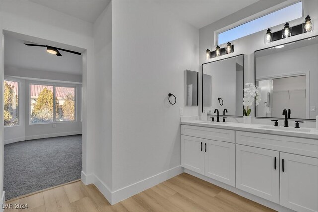 bathroom with wood-type flooring, vanity, and ceiling fan