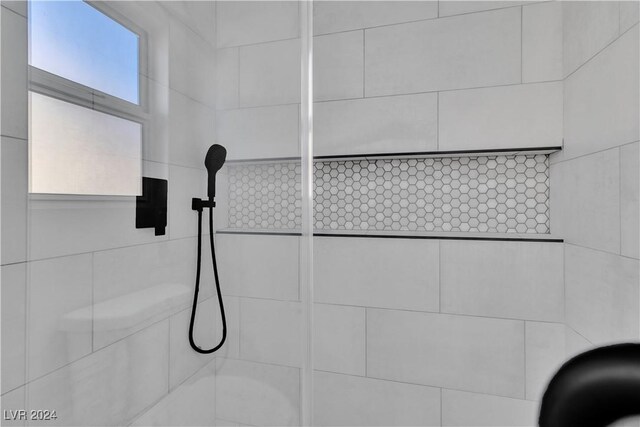 interior details with a tile shower