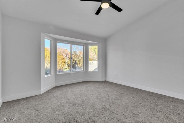 spare room with carpet, vaulted ceiling, and ceiling fan