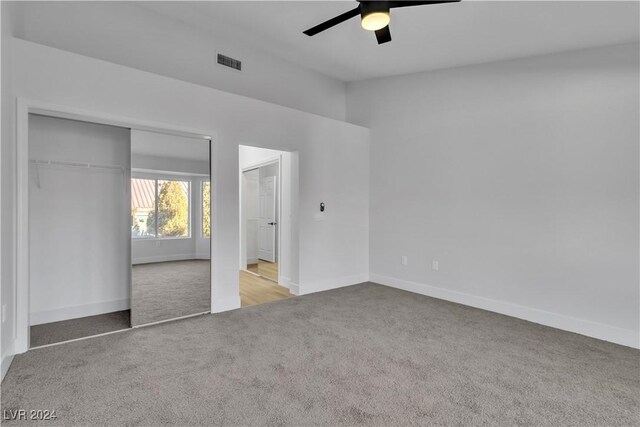 unfurnished bedroom featuring ceiling fan, light carpet, and a closet