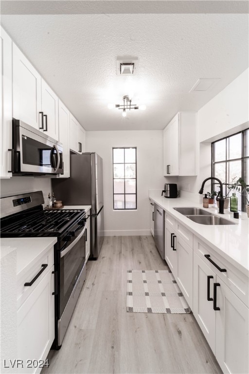 kitchen with white cabinets, appliances with stainless steel finishes, sink, and plenty of natural light