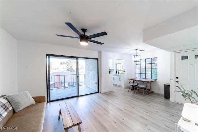 4724 Nara Vista Way Unit 204, Las Vegas, NV 89103 - living room with light wood-style floors, a chandelier, baseboards, and ceiling fan