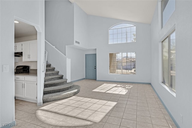 tiled entryway with a towering ceiling