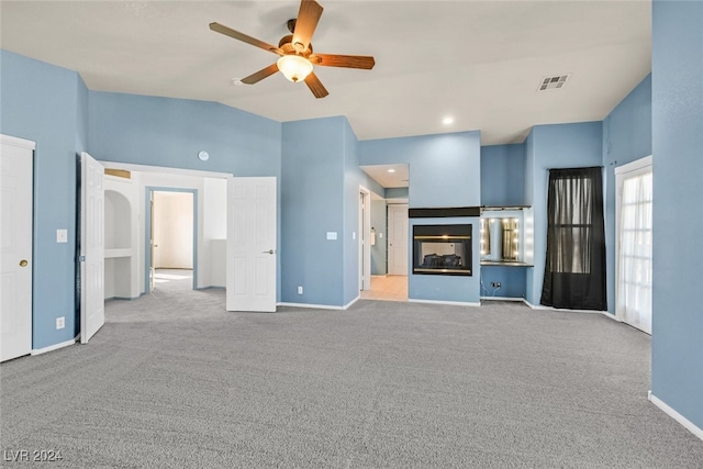 unfurnished living room featuring lofted ceiling, a multi sided fireplace, light carpet, and ceiling fan