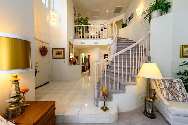 interior space featuring light tile patterned flooring, a high ceiling, and a notable chandelier