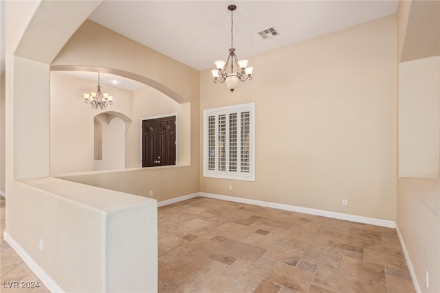 spare room featuring a chandelier