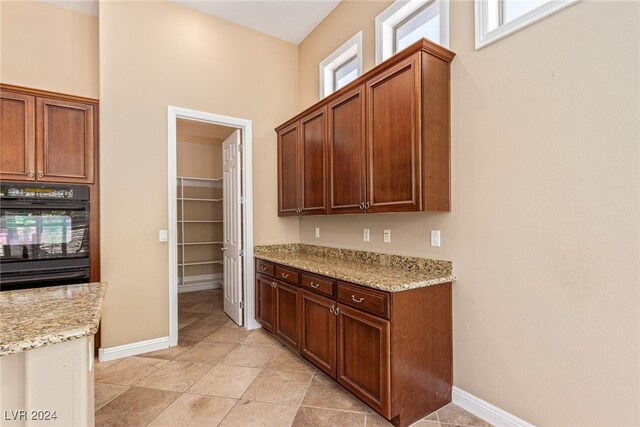 kitchen featuring light stone counters and double oven