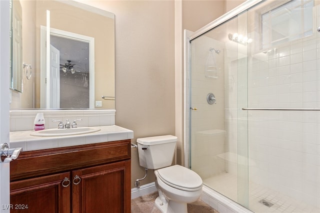 bathroom featuring vanity, toilet, and a shower with door