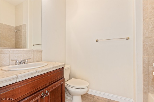 bathroom with tile patterned flooring, a tile shower, vanity, toilet, and decorative backsplash