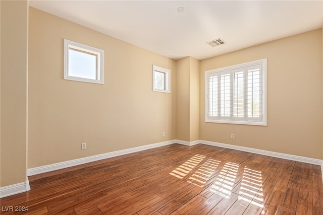 unfurnished room with wood-type flooring and a healthy amount of sunlight