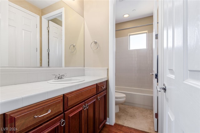 full bathroom with wood-type flooring, toilet, vanity, and tiled shower / bath