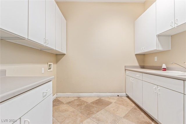 clothes washing area with washer hookup, cabinets, and sink