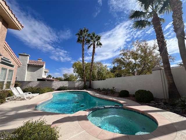 view of pool featuring a patio area and an in ground hot tub