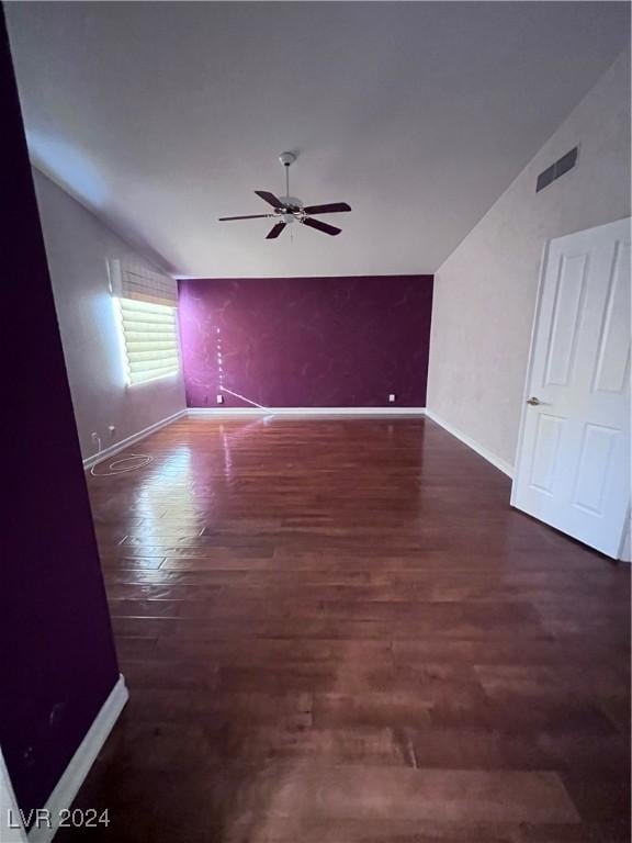 unfurnished room with dark hardwood / wood-style flooring, vaulted ceiling, and ceiling fan