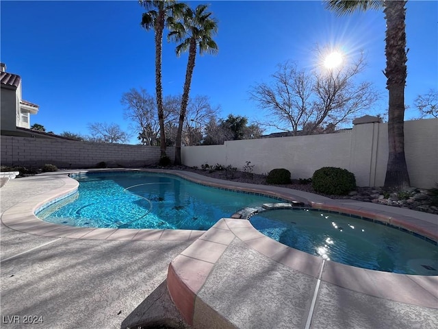 view of pool with an in ground hot tub