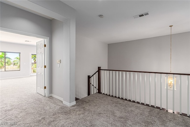 hallway with a chandelier and carpet