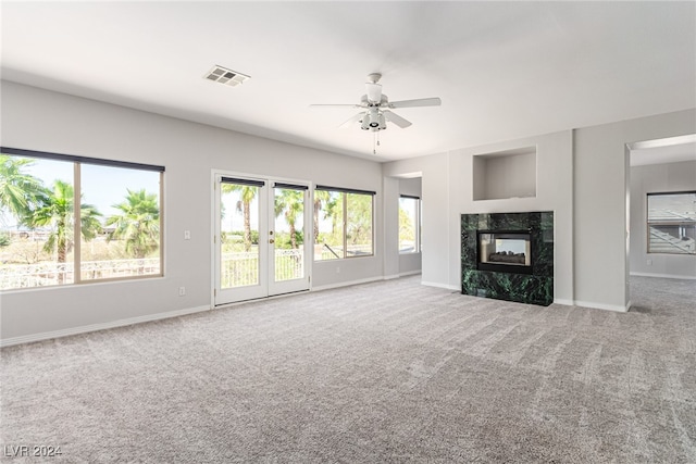 unfurnished living room with a fireplace, ceiling fan, and carpet floors