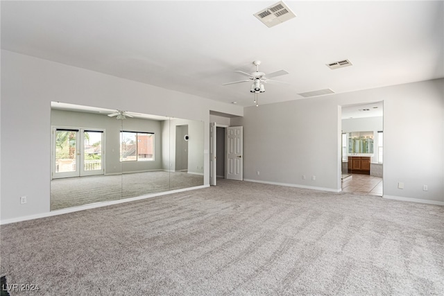 spare room featuring french doors, light colored carpet, and ceiling fan