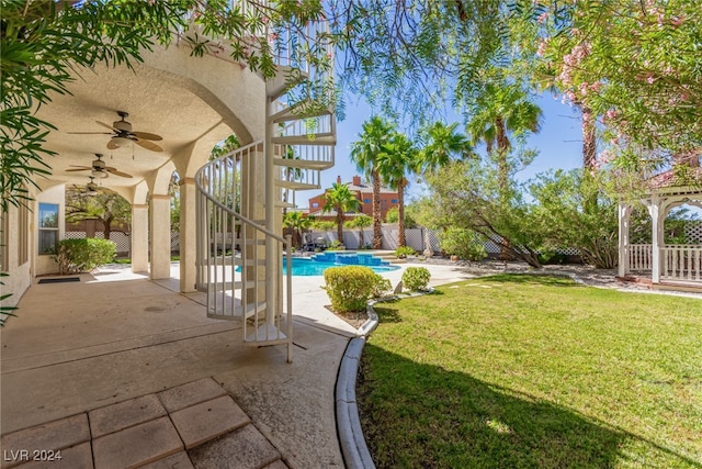 view of yard featuring a fenced in pool, a patio, and ceiling fan