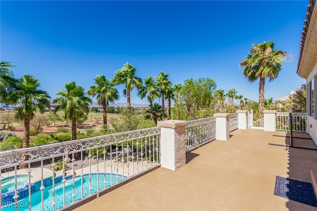 view of patio / terrace featuring a swimming pool with hot tub