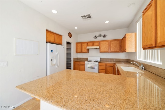 kitchen featuring kitchen peninsula, sink, light tile patterned flooring, and white appliances