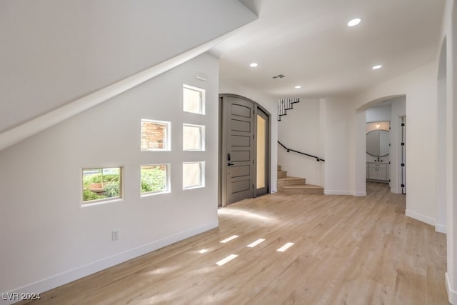 interior space featuring lofted ceiling and light wood-type flooring