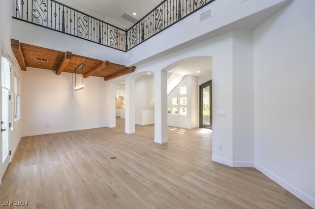 interior space featuring wooden ceiling, a towering ceiling, and light hardwood / wood-style floors