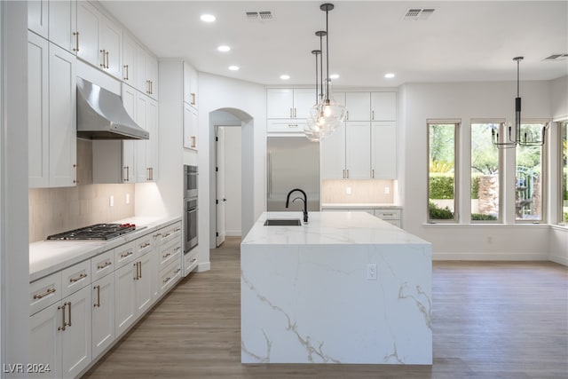 kitchen featuring sink, pendant lighting, a center island with sink, white cabinets, and appliances with stainless steel finishes