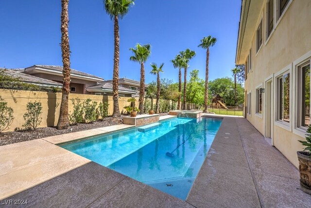 view of swimming pool featuring an in ground hot tub and a patio