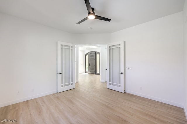 unfurnished room featuring ceiling fan, french doors, and light hardwood / wood-style flooring