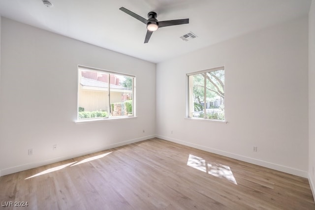 spare room with ceiling fan, a healthy amount of sunlight, and light hardwood / wood-style flooring