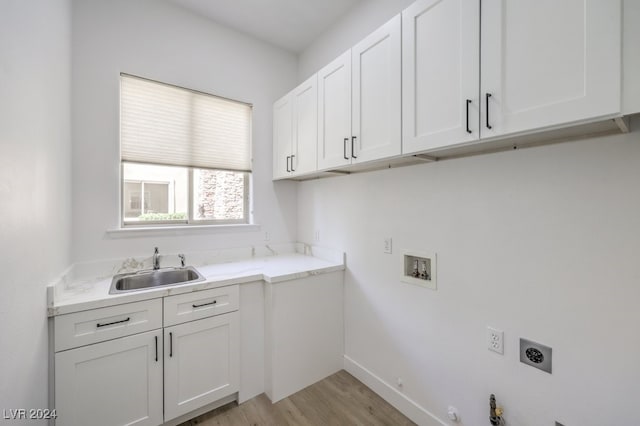 laundry area with gas dryer hookup, cabinets, sink, light hardwood / wood-style flooring, and hookup for an electric dryer