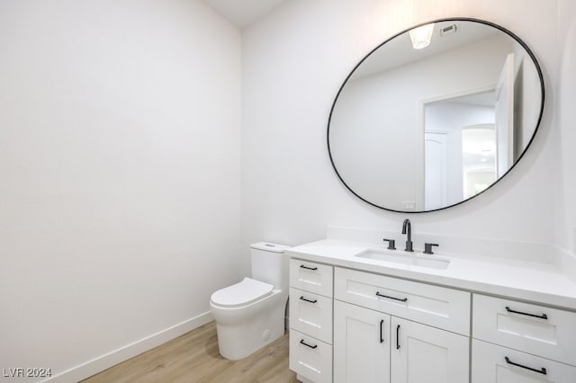 bathroom with hardwood / wood-style floors, vanity, and toilet