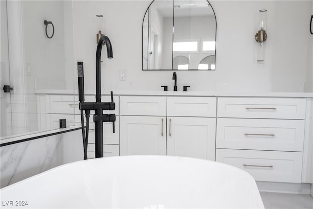 bathroom featuring a washtub, vanity, and tile walls