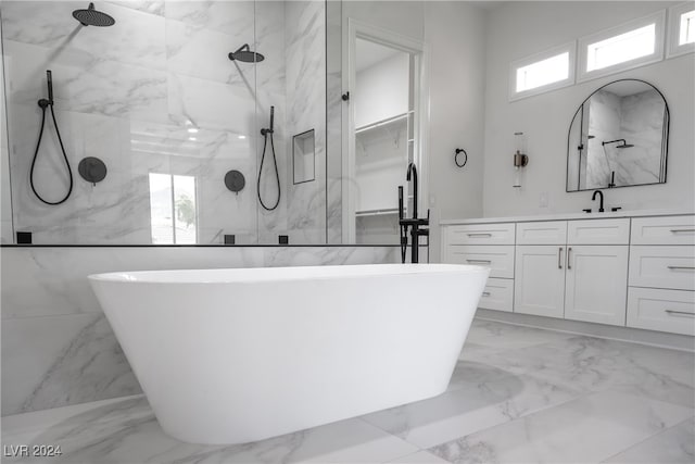 bathroom featuring shower with separate bathtub, vanity, and tile walls