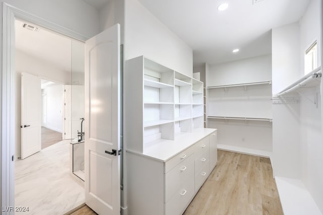 walk in closet featuring light hardwood / wood-style flooring