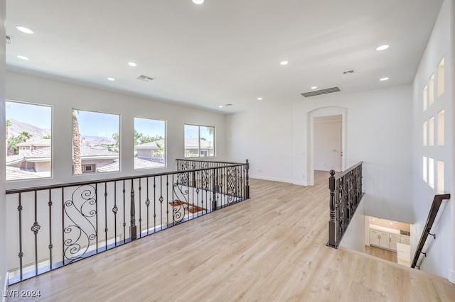 corridor with plenty of natural light and light hardwood / wood-style flooring