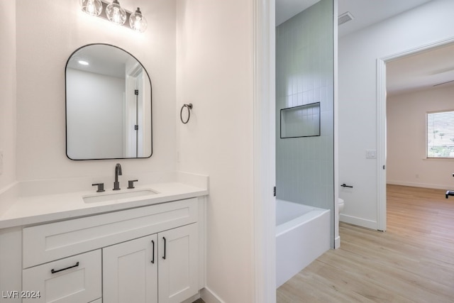 bathroom with hardwood / wood-style floors, vanity, and toilet