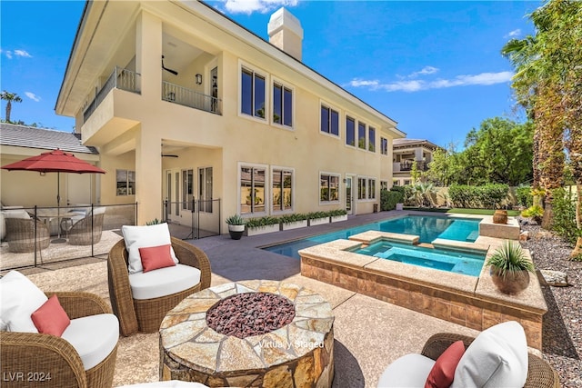 view of swimming pool featuring a patio area, an in ground hot tub, and a fire pit