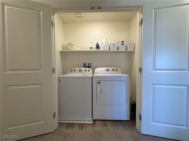 washroom featuring wood-type flooring and independent washer and dryer