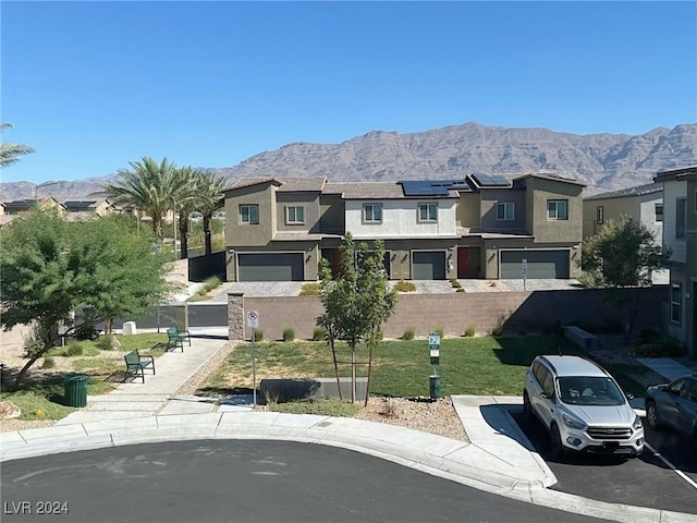 view of front of house featuring a mountain view, solar panels, and a garage